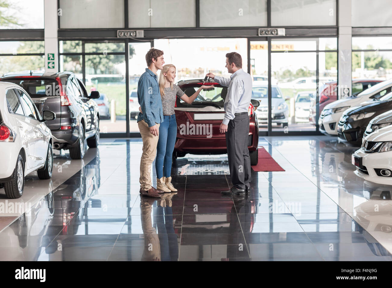 Salesman giving key smiling couple hi-res stock photography and images ...
