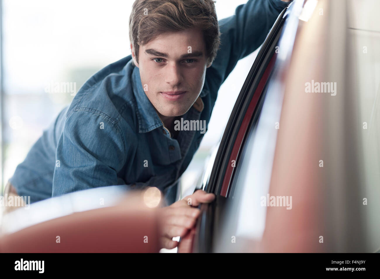 Man looking at new car at car dealership Stock Photo Alamy