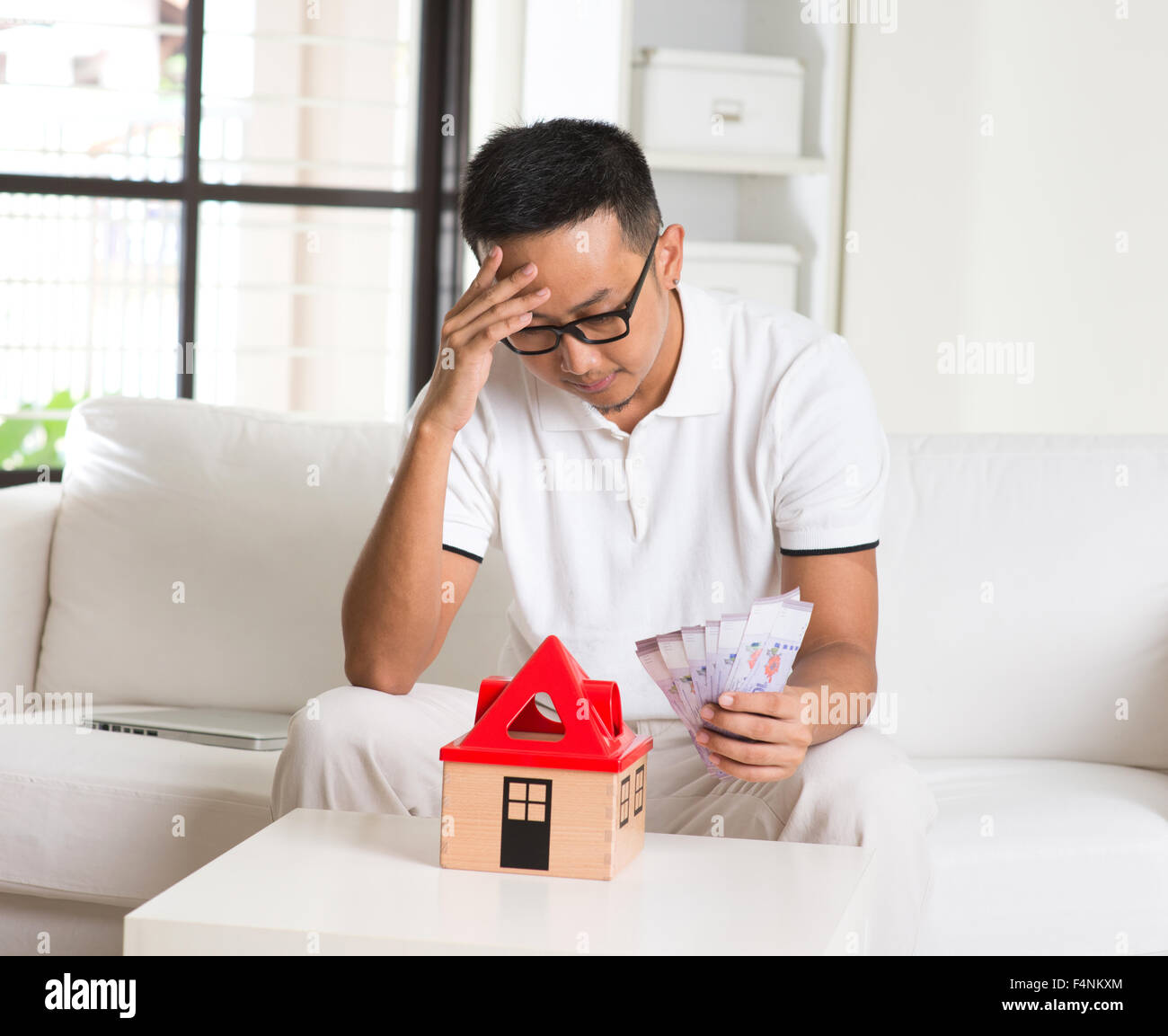 asian man stress on high property price and debts Stock Photo