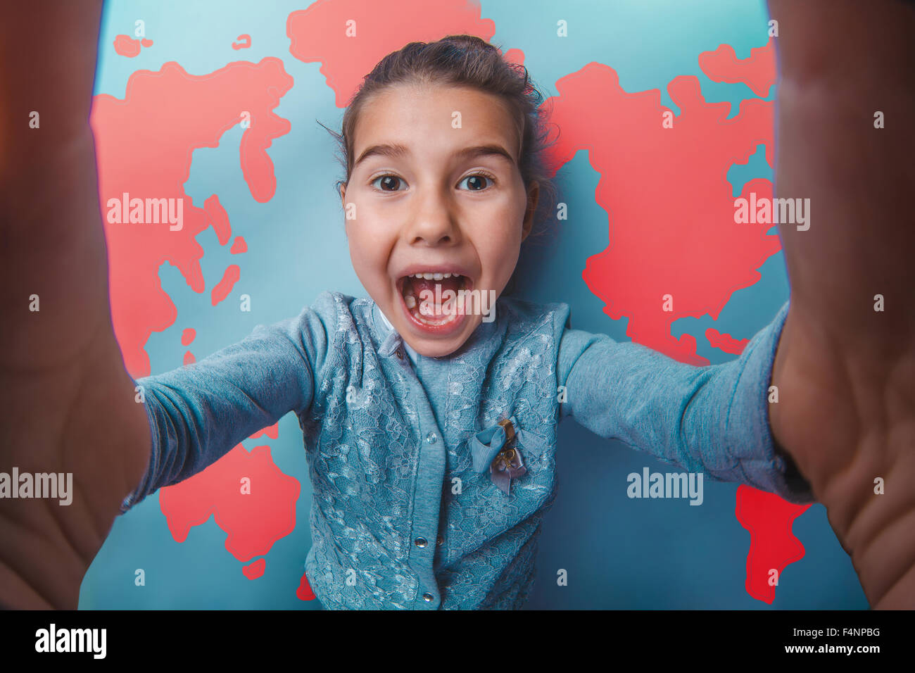 teen girl shouting stretched her arms behind world map background Stock Photo