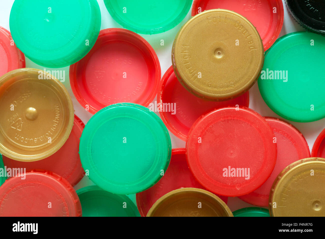 red and green plastic milk bottle tops and gold bottle tops - HDPE high density polyethylene Stock Photo