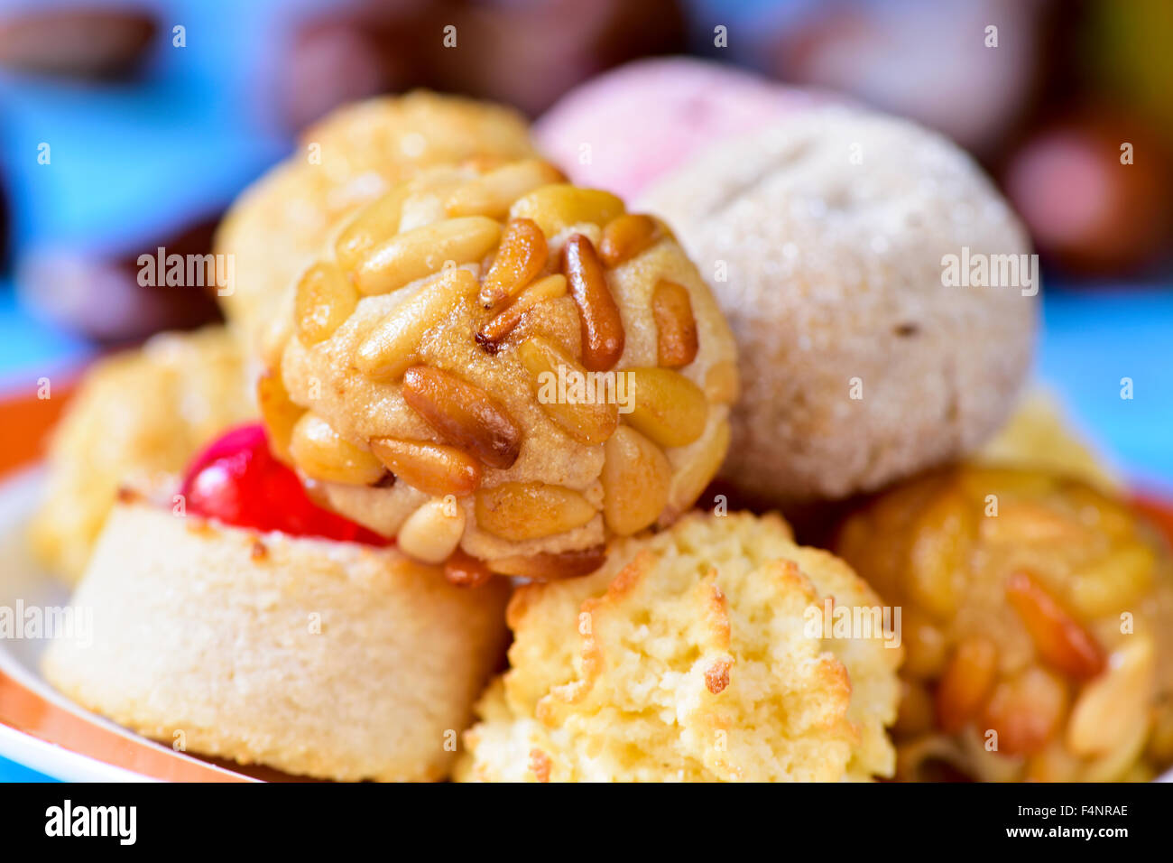 closeup of a plate with some different panellets, typical pastries of Catalonia, Spain, eaten in All Saints Day, on a blue rusti Stock Photo