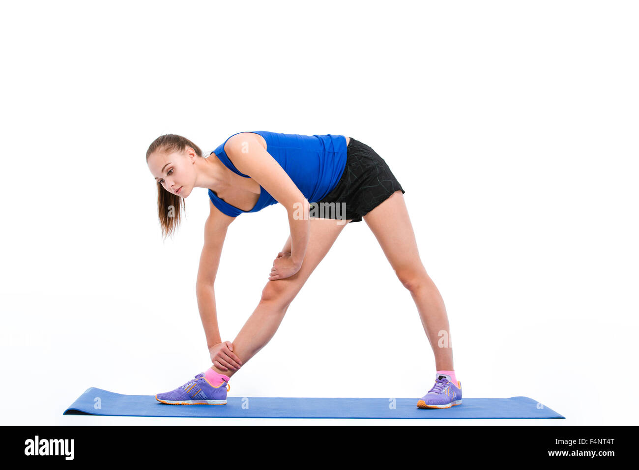 Portrait of a fitness woman doing stretching exercises on yoga mat ...