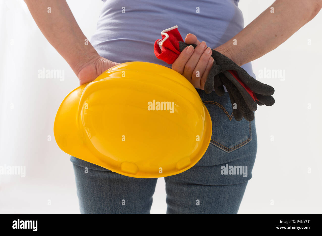 Close up back-view of woman builder with hardhat in hands Stock Photo