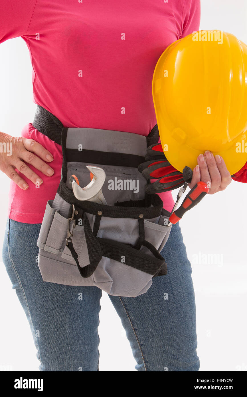 Close up of woman builder with hardhat in hands and tools belt Stock Photo