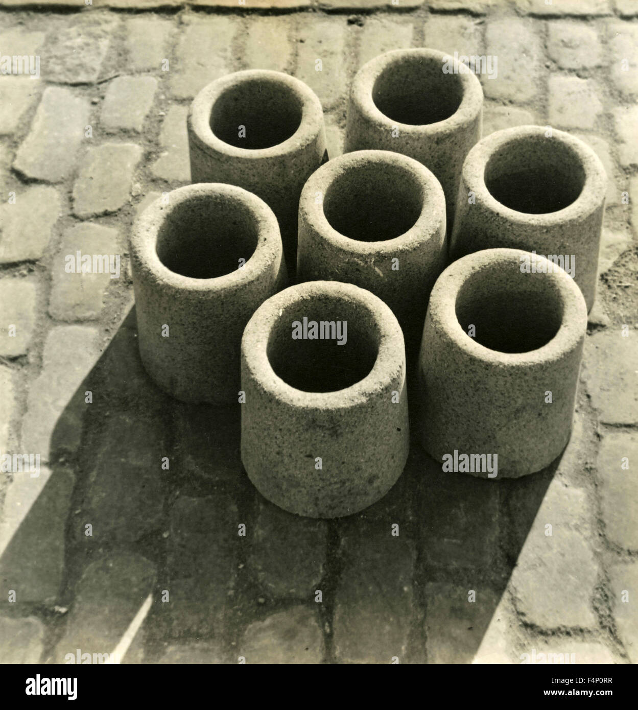 Seven short concrete pipes resting on the road Stock Photo