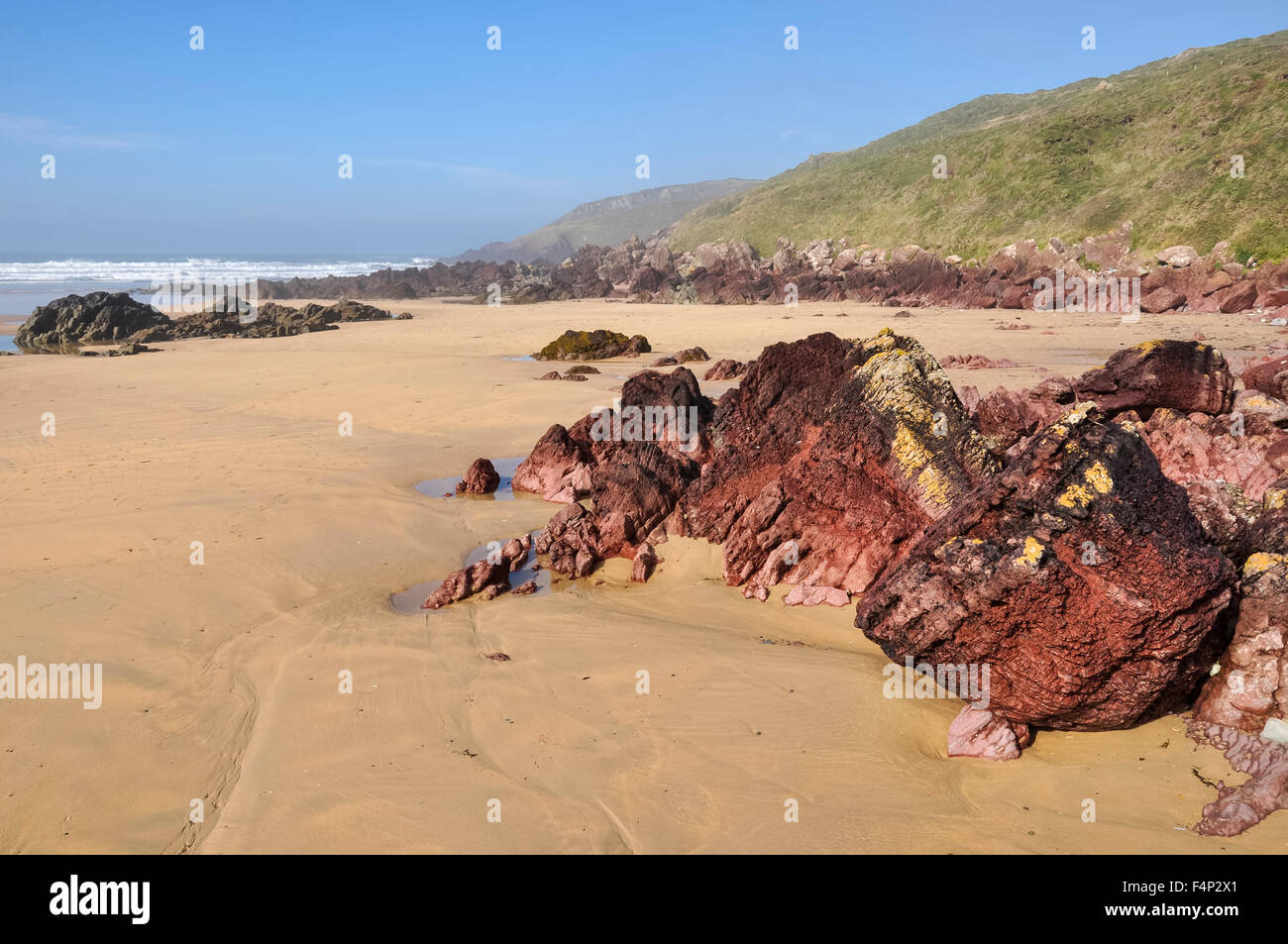 Beautiful beach at Freshwater West in Pembrokeshire, Wales. A sunny morning on the beach with red rocks and sand exposed. Stock Photo