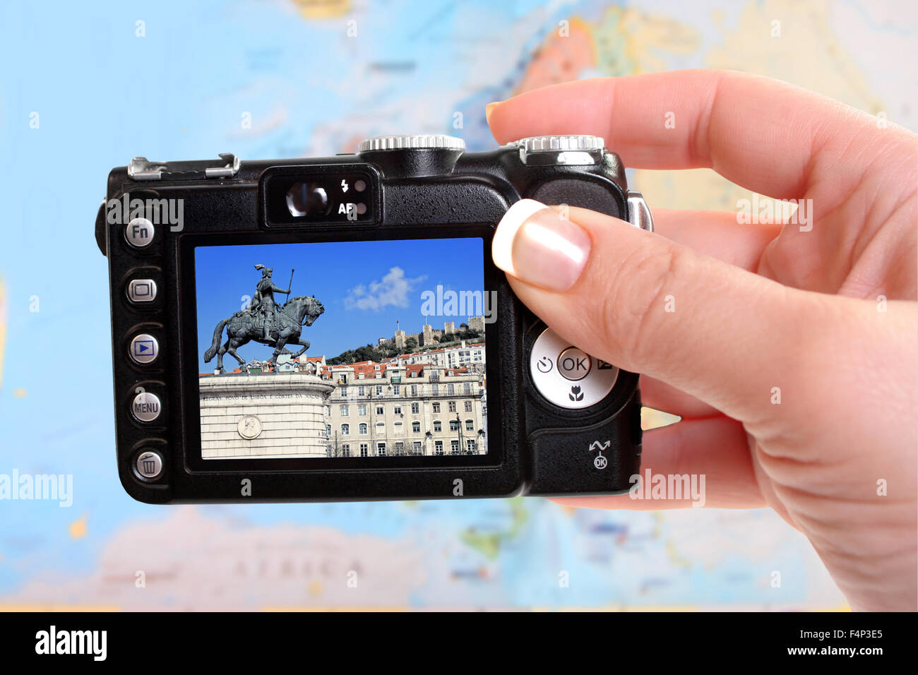 A travel concept showing a woman's  hand holding a  camera taking a picture of Lisbon Portugal with European blurred map in the Stock Photo