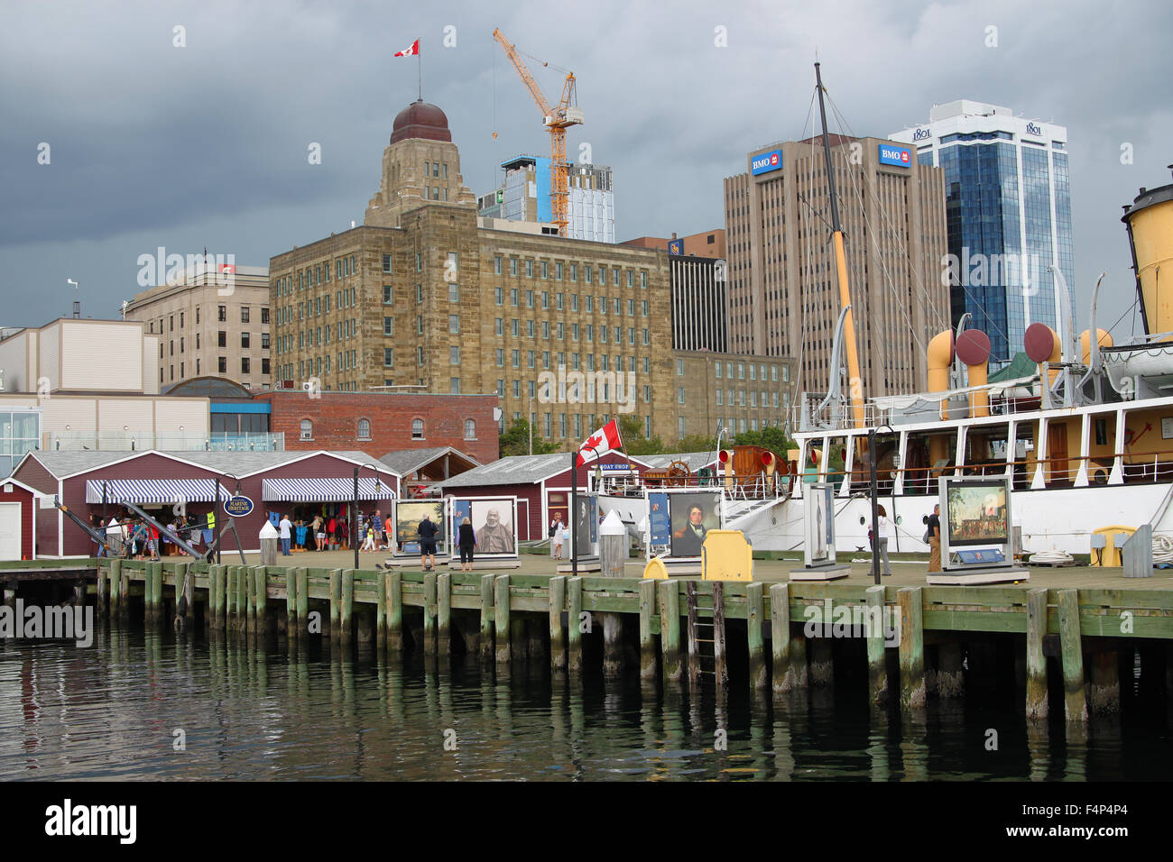 Halifax, Nova Scotia, Canada, August 9, 2014: Touristic harbor waterfront with shops and tourist, gray skies in the background i Stock Photo