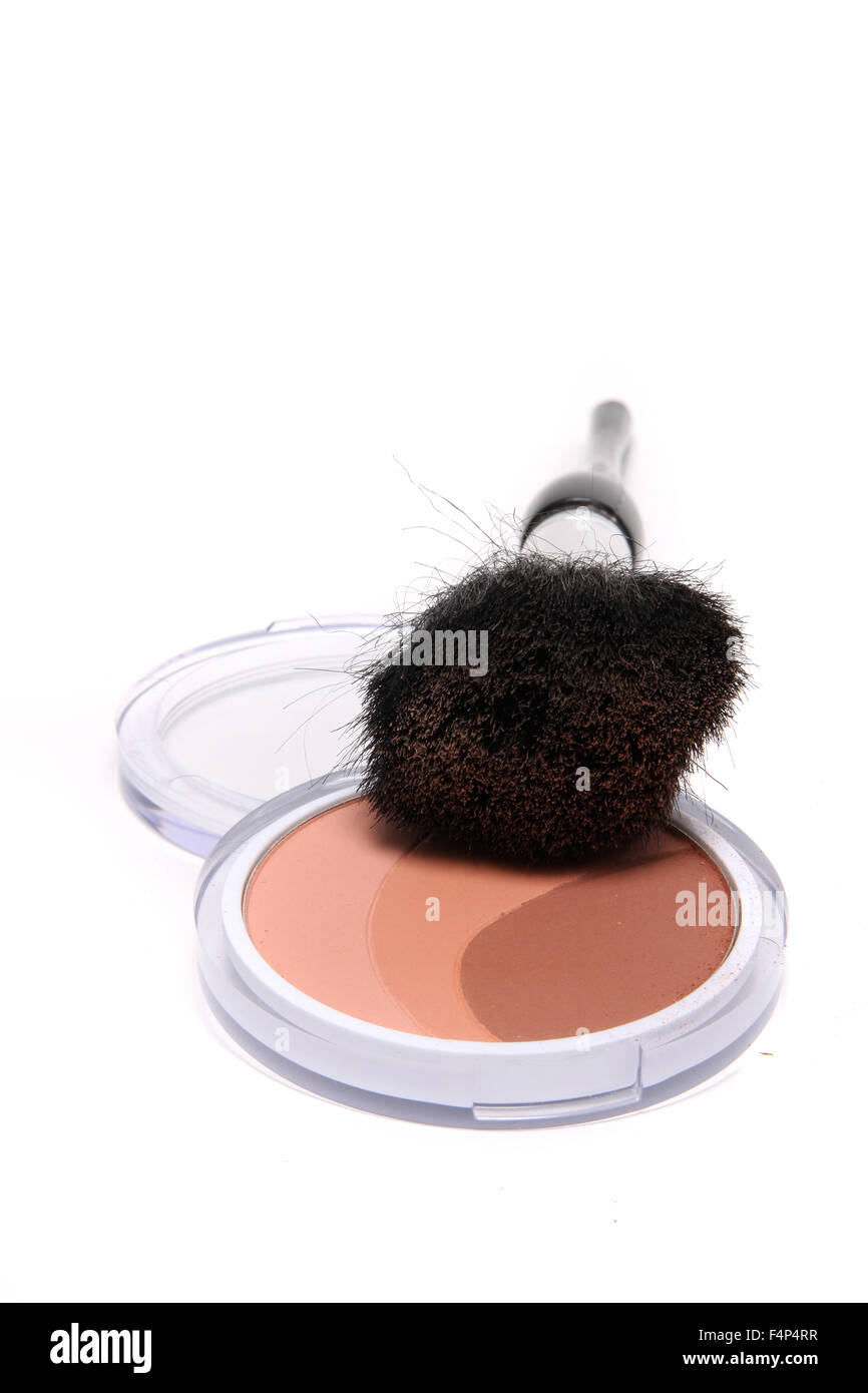 Powder bronzer in three shades of tan in a compact case with soft brush on a white background Stock Photo