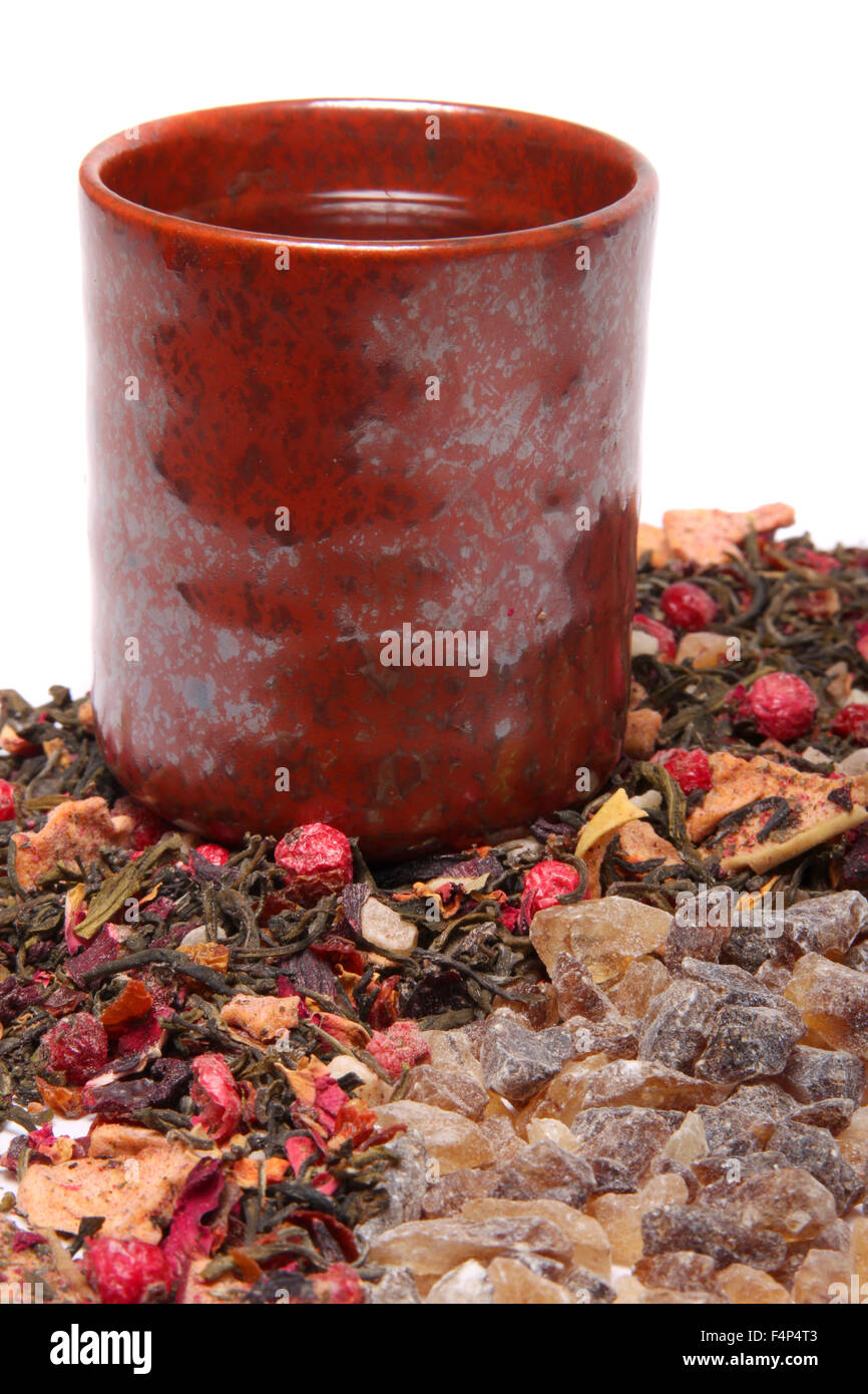 Cup of tea with dried loose berry mix beside brown rock sugar to sweeten the beverage Stock Photo