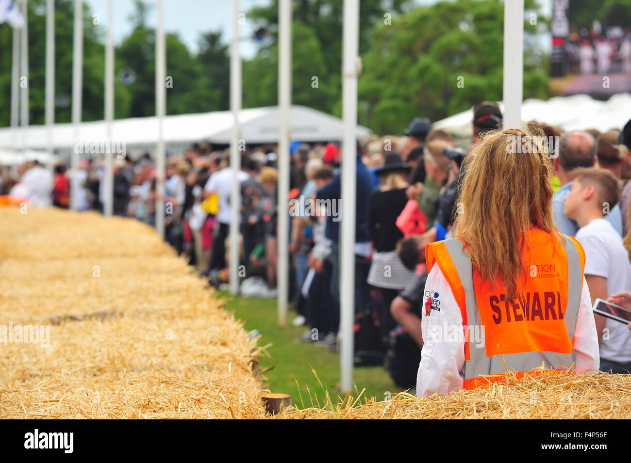 A woman in an orange Steward bib at the Goodwood Festival of Speed in the UK. Stock Photo