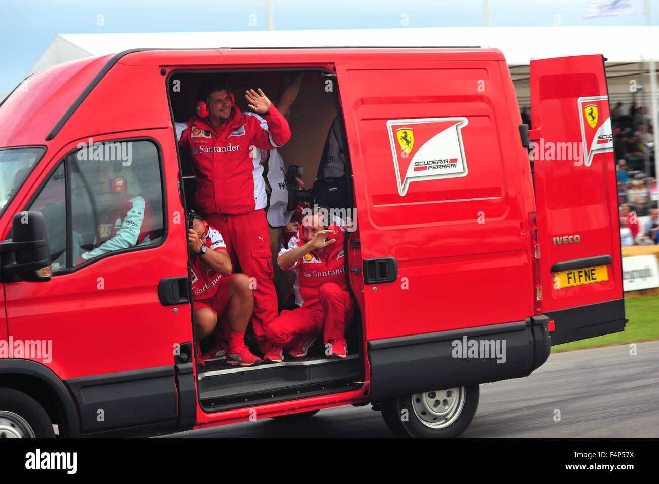 The Ferrari F1 team mechanics wave from a van at the Goodwood Festival of Speed in the UK. Stock Photo