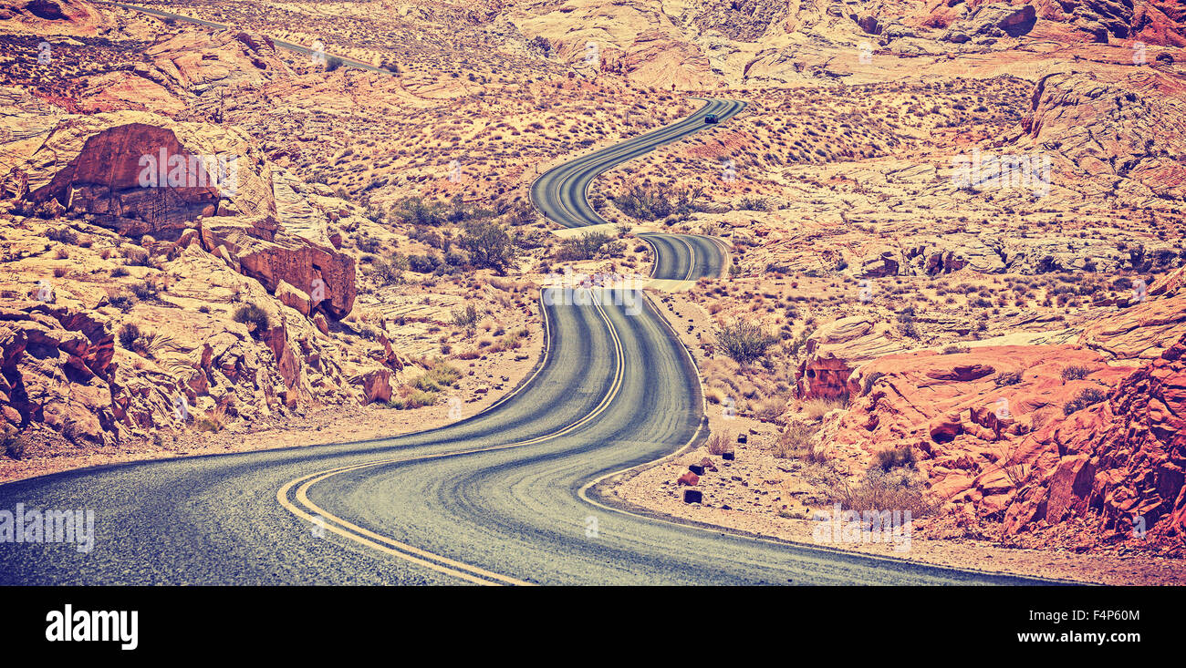 Vintage toned curved desert highway, travel adventure concept, USA. Stock Photo