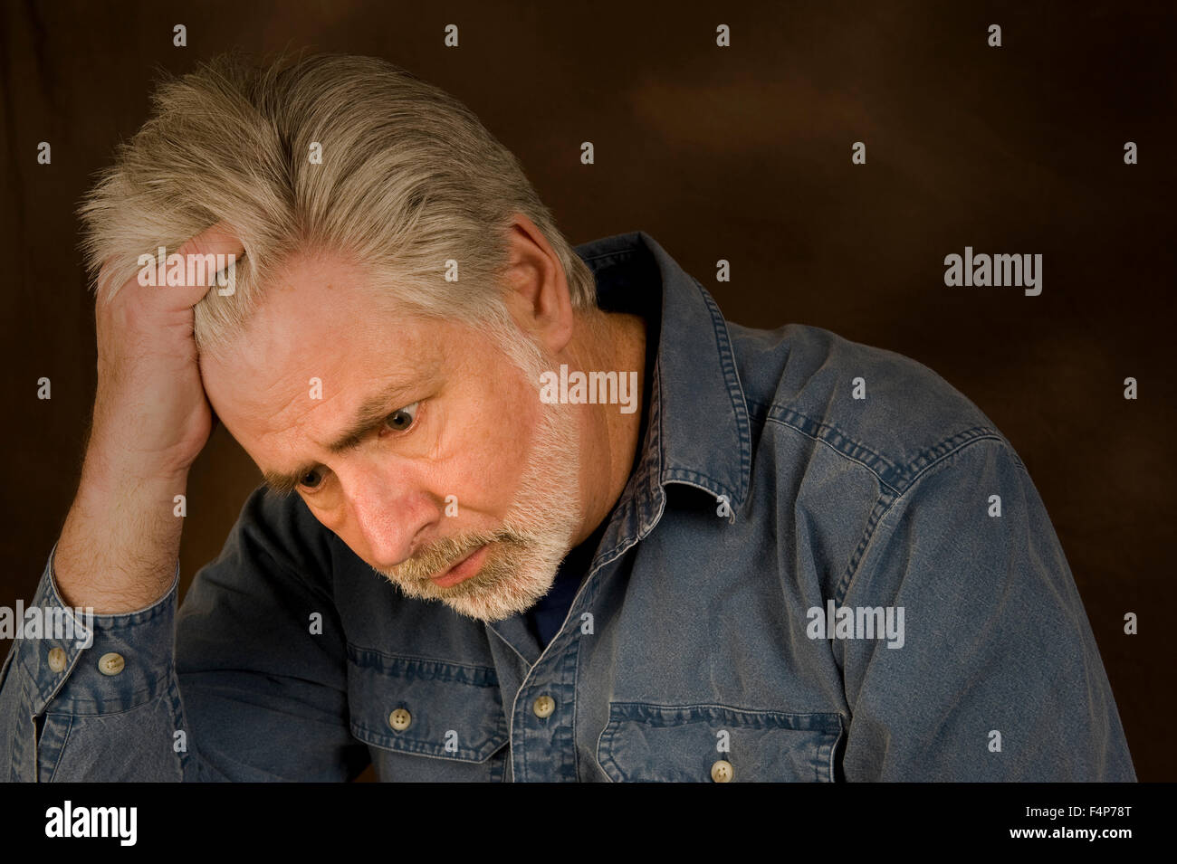 A middle aged man feeling overwhelmed Stock Photo