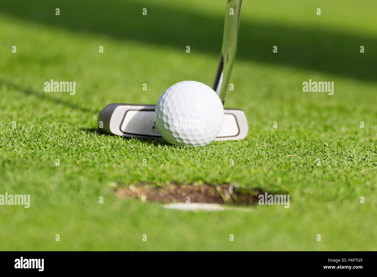 Golf ball in front of driver Stock Photo