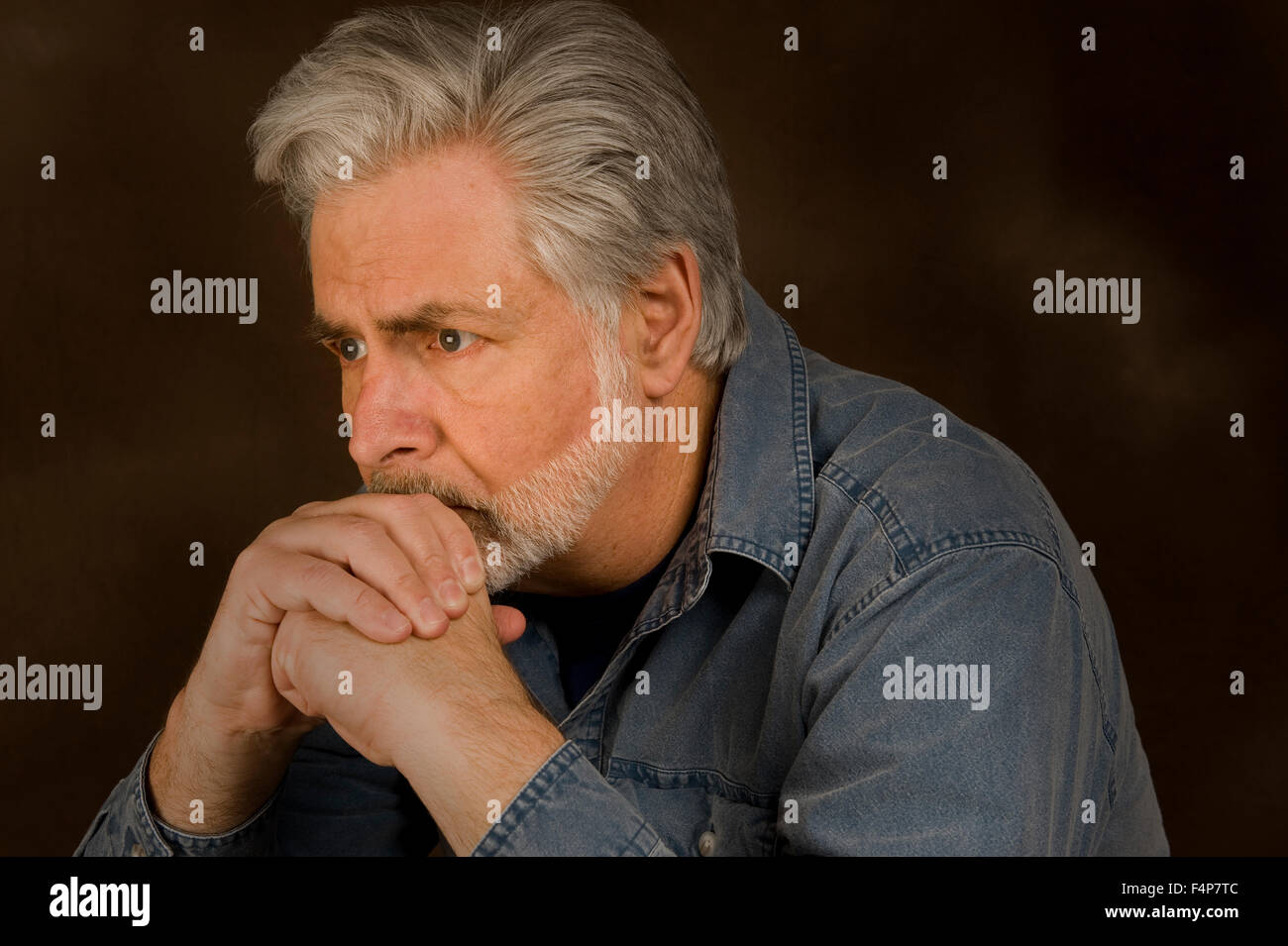 A middle aged man is Worried Concerned or Thinking Deeply Stock Photo