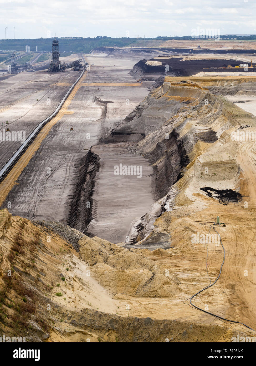 Bucket-wheel excavator in the cratered landscape of the surface mining field at Garzweiler, Germany's largest opencast pit. Stock Photo