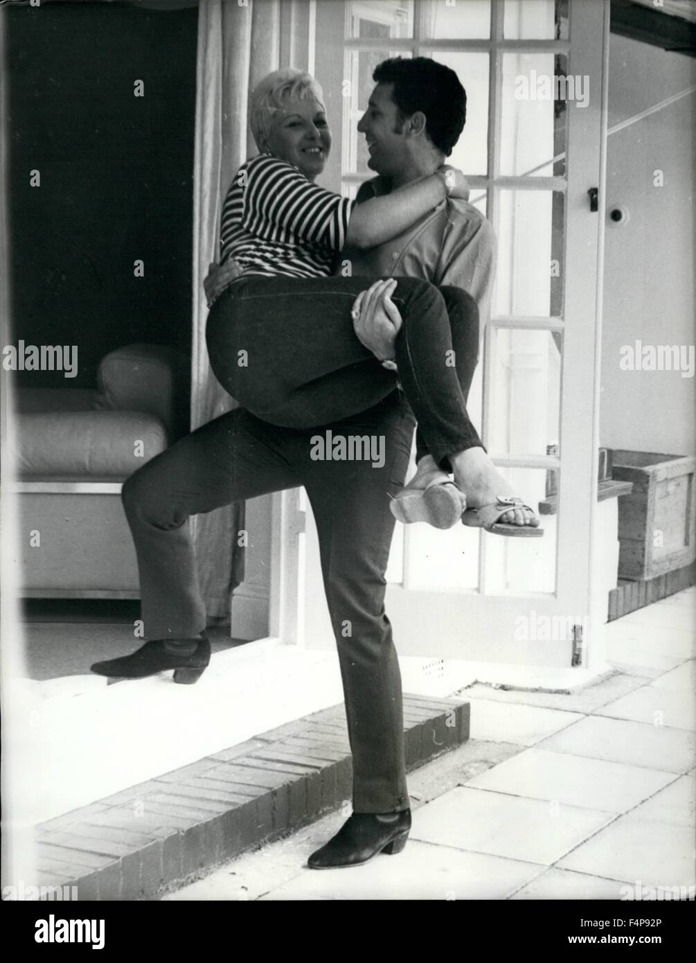 1970 - Tom Jones Moves House. The pop star Tom Jones (his hit in the charts ''I'll Never Fall In Love Again'') is busy moving from Shepperton to Sunbury where he's bought a modern &pound;25,000 house. Giving Tom a hand with humping their personal bits and pieces are his wife, Linda and their son Mark (10). It's a new home for Linda. Tom Jones famous pop star carries his wife over the threshold of their new home at Sunbury, Surrey. © Keystone Pictures USA/ZUMAPRESS.com/Alamy Live News Stock Photo