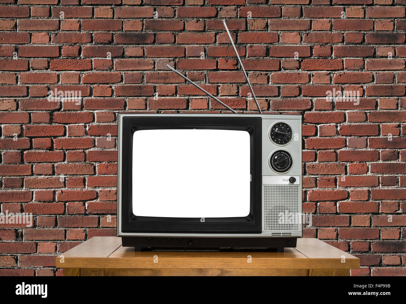 Old analogue television with cut out screen and brick wall. Stock Photo