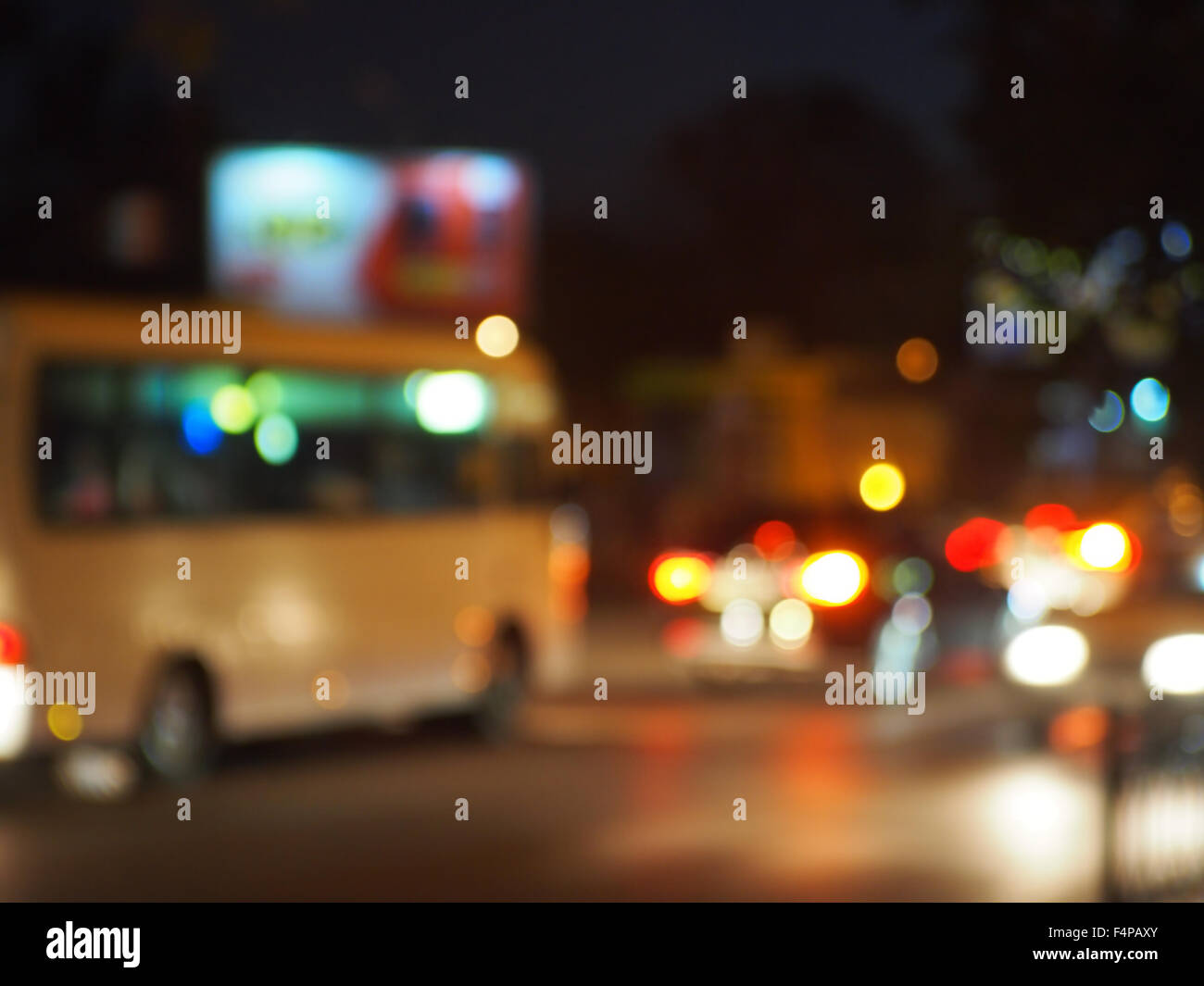 Abstract night scene with bus and headlights. Blur and defocused lights from the headlights of cars and traffic lights can be us Stock Photo