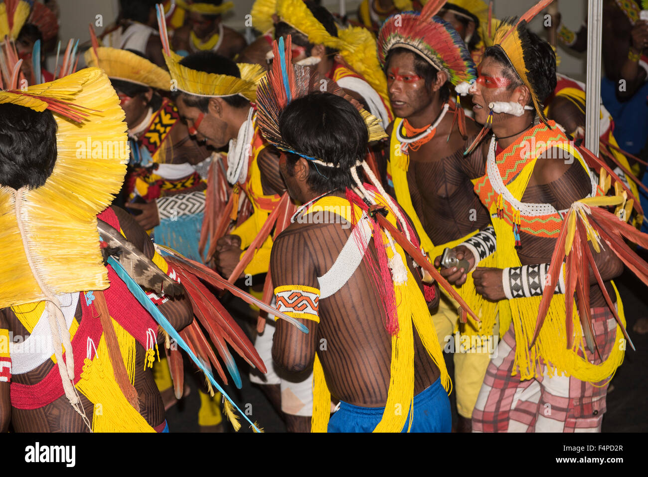 Palmas, Brazil. 20th Oct, 2015. Kayapo warriors from the remote village of Gorotire dressed in traditional feather headdress and beadwork dance during a cultural presentation at the first ever International Indigenous Games, in the city of Palmas, Tocantins State, Brazil. The games will start with an opening ceremony on Friday the 23rd October. Credit:  Sue Cunningham Photographic/Alamy Live News Stock Photo