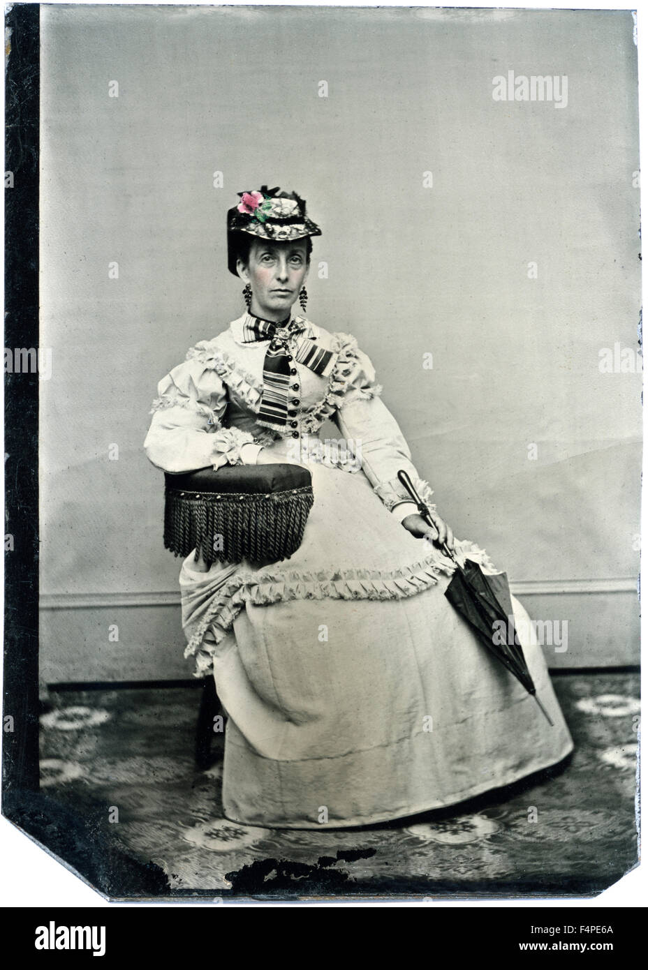 Portrait of Seated Adult Woman Wearing Hat and Holding Parasol, Hand-Colored Tintype, circa 1870 Stock Photo