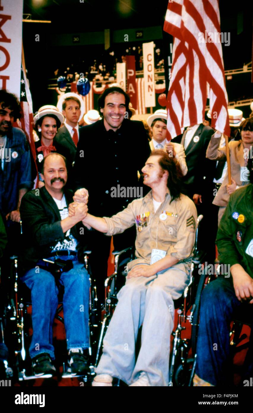 On the set, Oliver Stone between Ron Kovic and Tom Cruise / Born on the Fourth of July / 1989 directed by Oliver Stone [Universal Pictures] Stock Photo