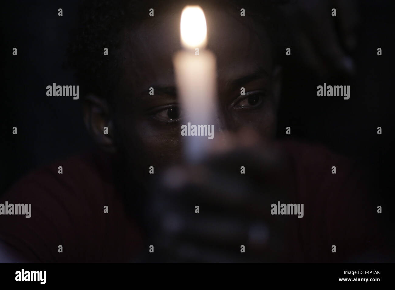 Jerusalem, Israel. 21st Oct, 2015. A member of the Eritrean community in Israel lights a candle during a memorial ceremony for Eritrean asylum seeker Habtom Zarhum in Tel Aviv, Israel, on Oct. 21, 2015. Zarhum died of his injuries after he was shot by an Israeli security guard at a bus station in the southern city of Be'er Sheva after being mistaken as an assailant in an attack that killed an Israeli soldier. An angry mob then hit him, kicked his head and threw chairs and a bench at him. Credit:  JINI/Daniel Bar-On/Xinhua/Alamy Live News Stock Photo