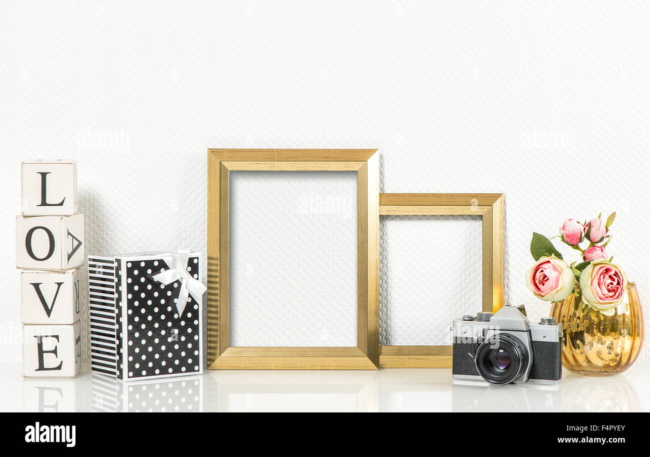 Golden picture frames, rose flowers and no name vintage photo camera. Retro style decorations Stock Photo