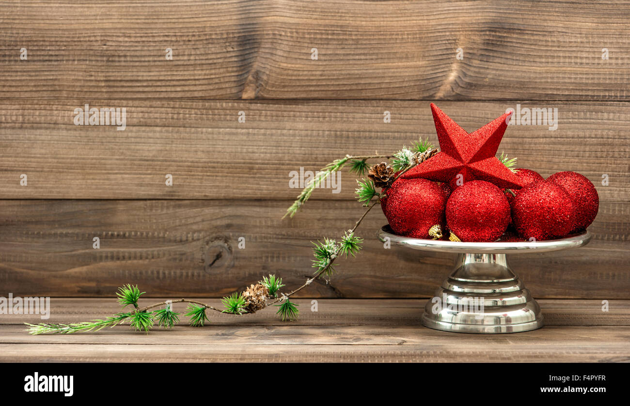 Christmas decoration with red baubles on rustic wooden background. Vintage arrangement. Retro style toned picture Stock Photo