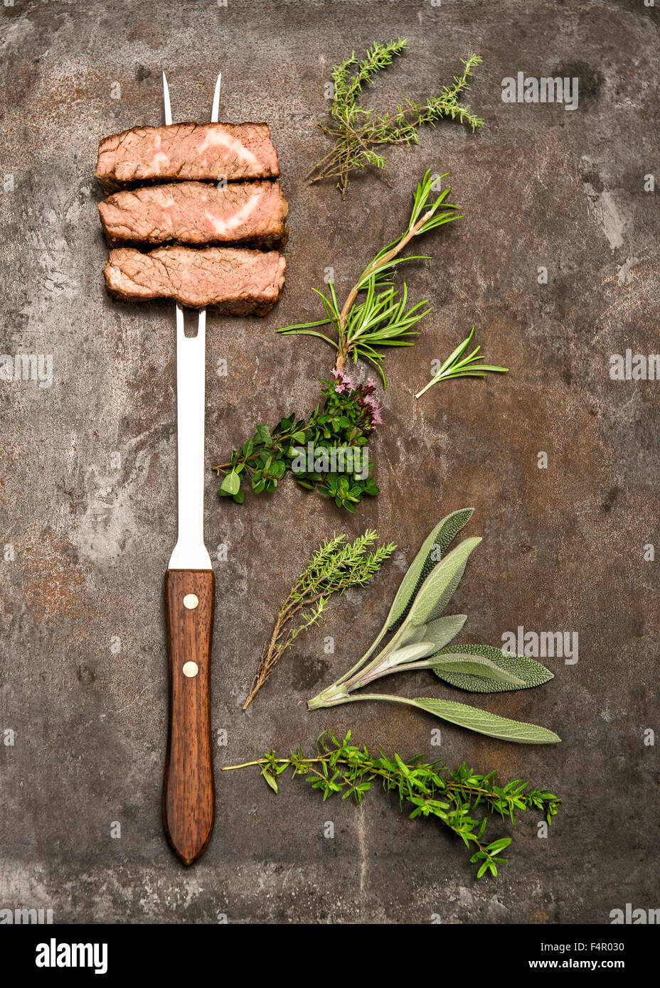 Grilled beef meat with herbs and spices on rustic metal background ...