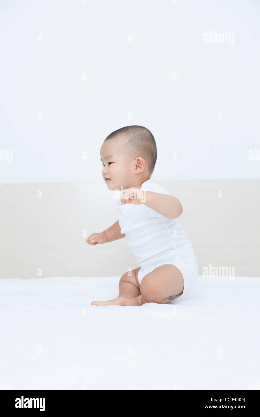 Cute Chinese baby boy playing in bed, shot in Beijng, China Stock Photo