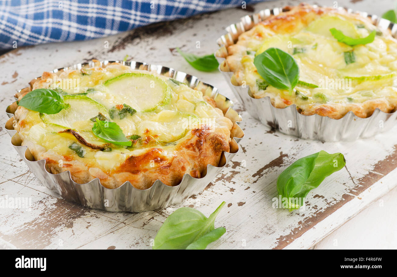 Tart with zucchini and cheese on a white wooden background. Selective focus Stock Photo