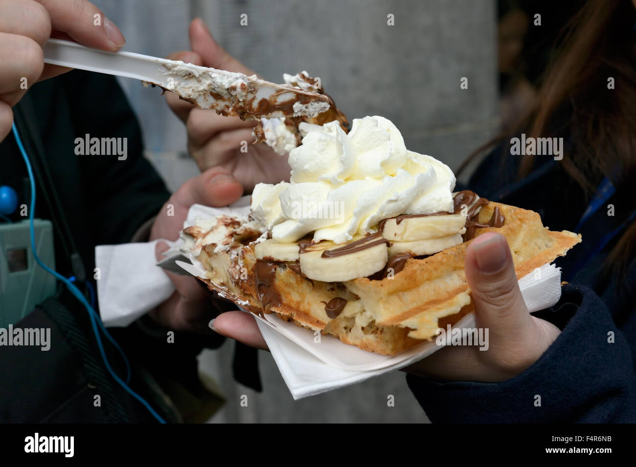 Tourists sharing Brussels delight – gaufre or wafer with cream and fruits Stock Photo