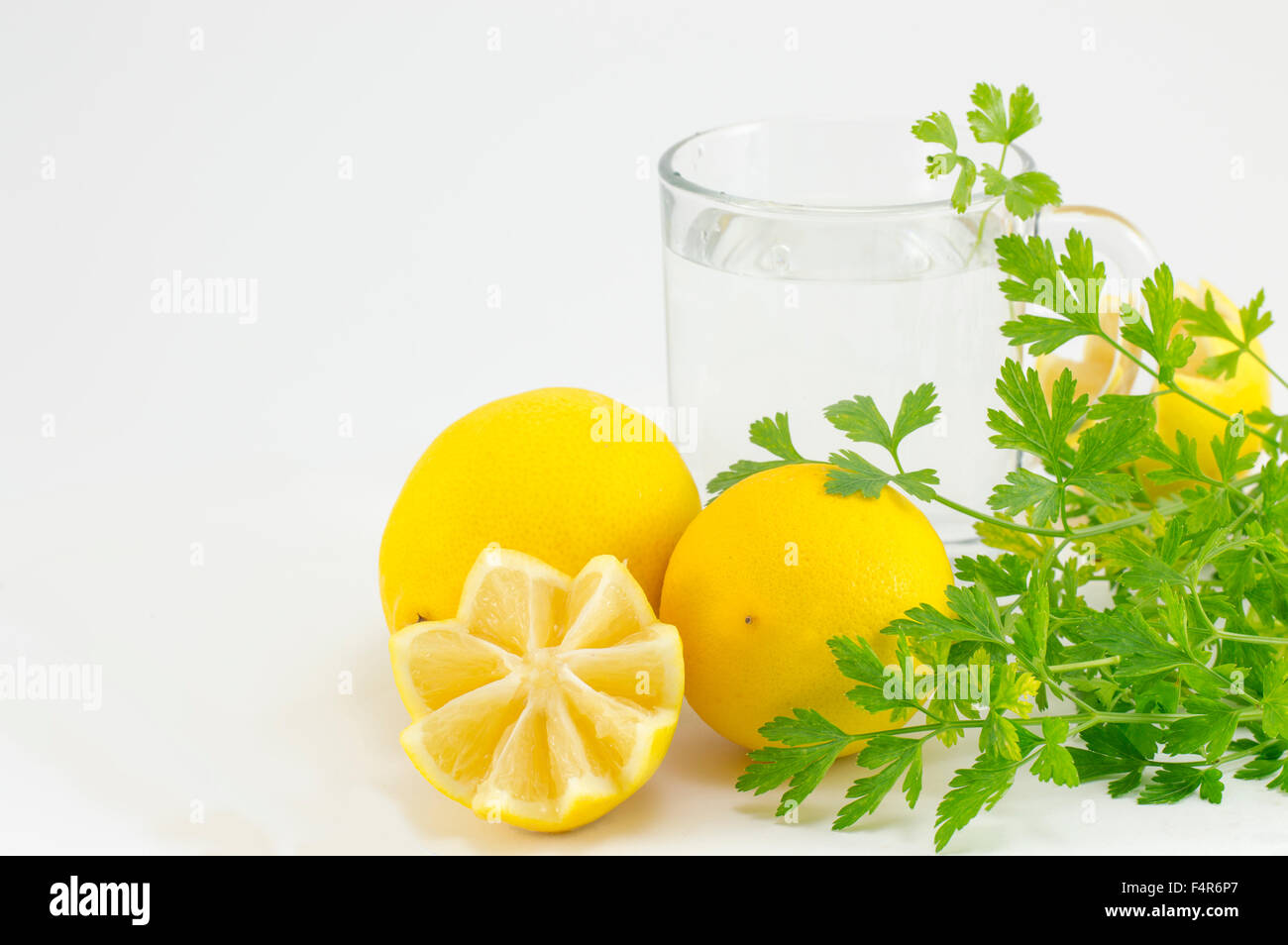 Decorative lemons, parsley and glass of water. Healthy lifestyle abstract Stock Photo