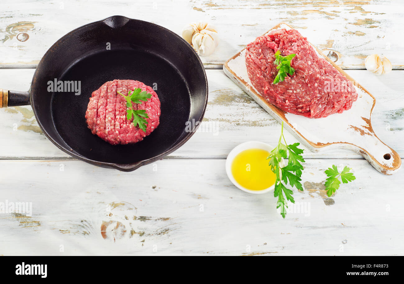 Raw beef burger patty on iron pan. Top view Stock Photo Alamy