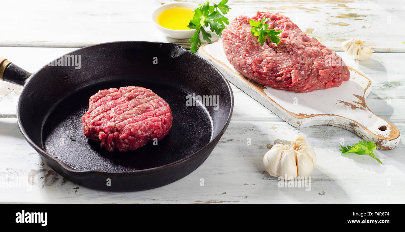 Raw ground beef  patty on pan. Selective focus Stock Photo