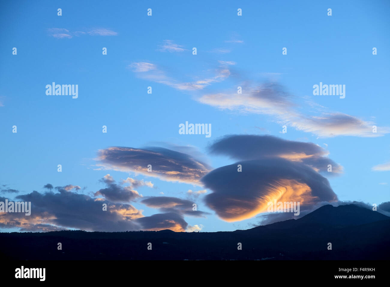 Lenticular cloud system catching the first light of dawn over mount Teide on Tenerife, Canary Islands, Spain. Stock Photo