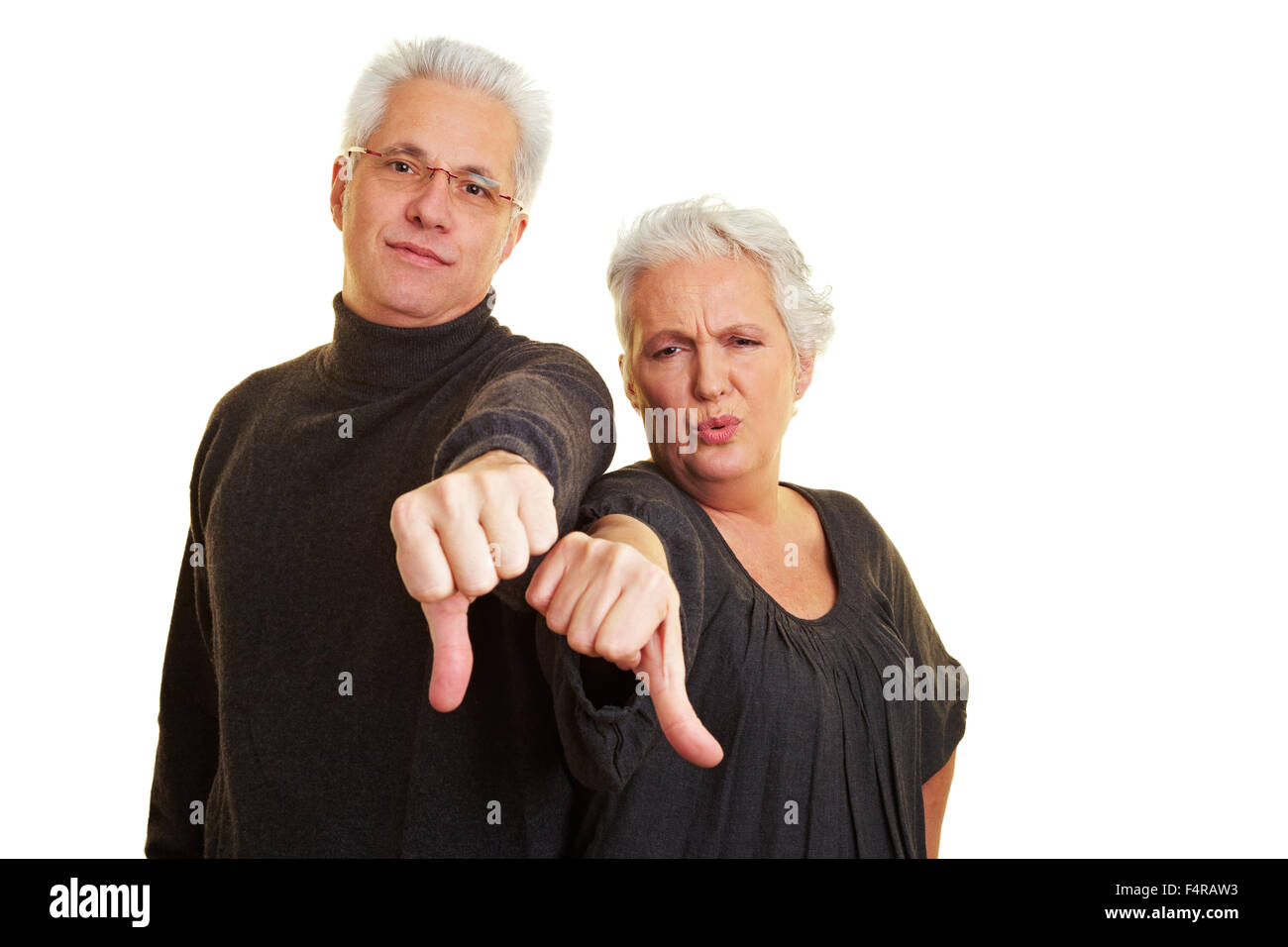 Two dissappointed senior citizens holding their thumbs down Stock Photo
