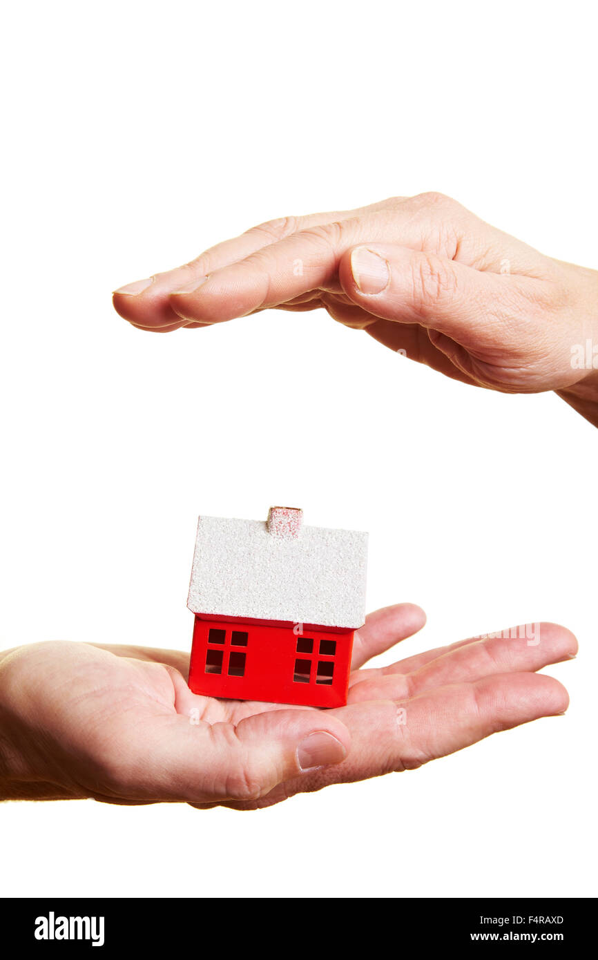 Hand protecting a small red miniature house Stock Photo