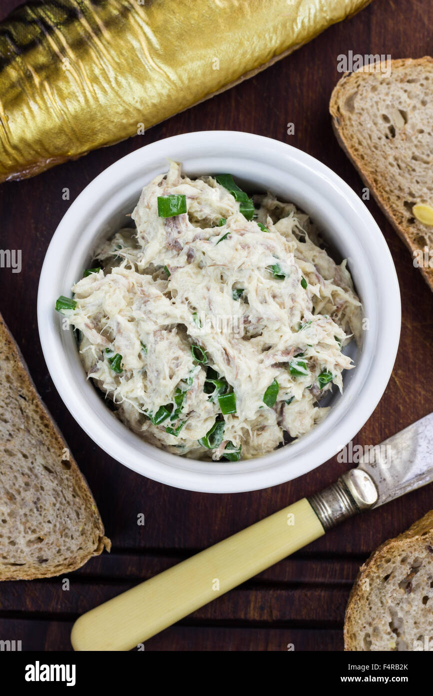 Closeup of freshly prepared mackerel pate next to piece of bread and