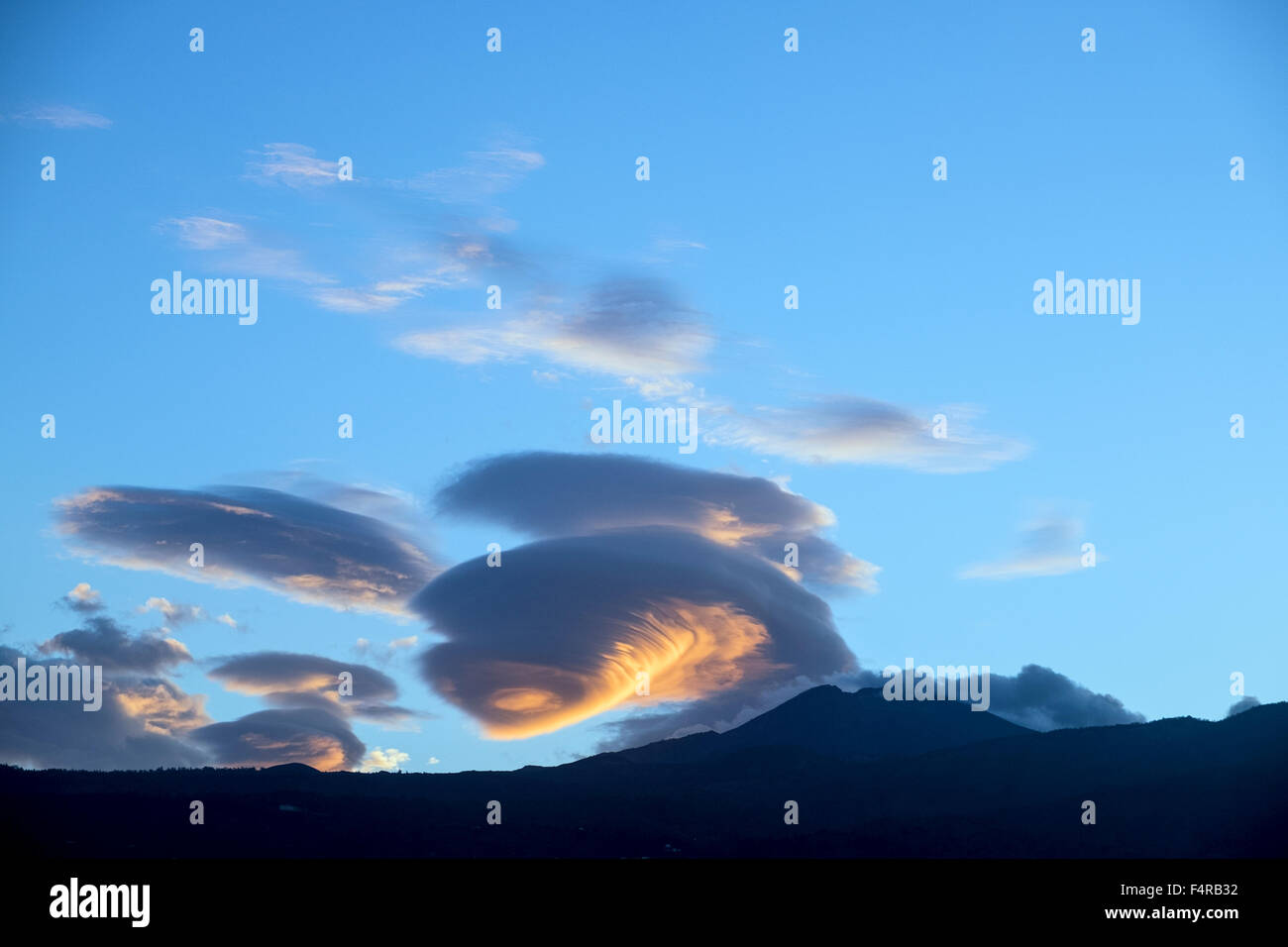 Lenticular cloud system catching the first light of dawn over mount Teide on Tenerife, Canary Islands, Spain. Stock Photo