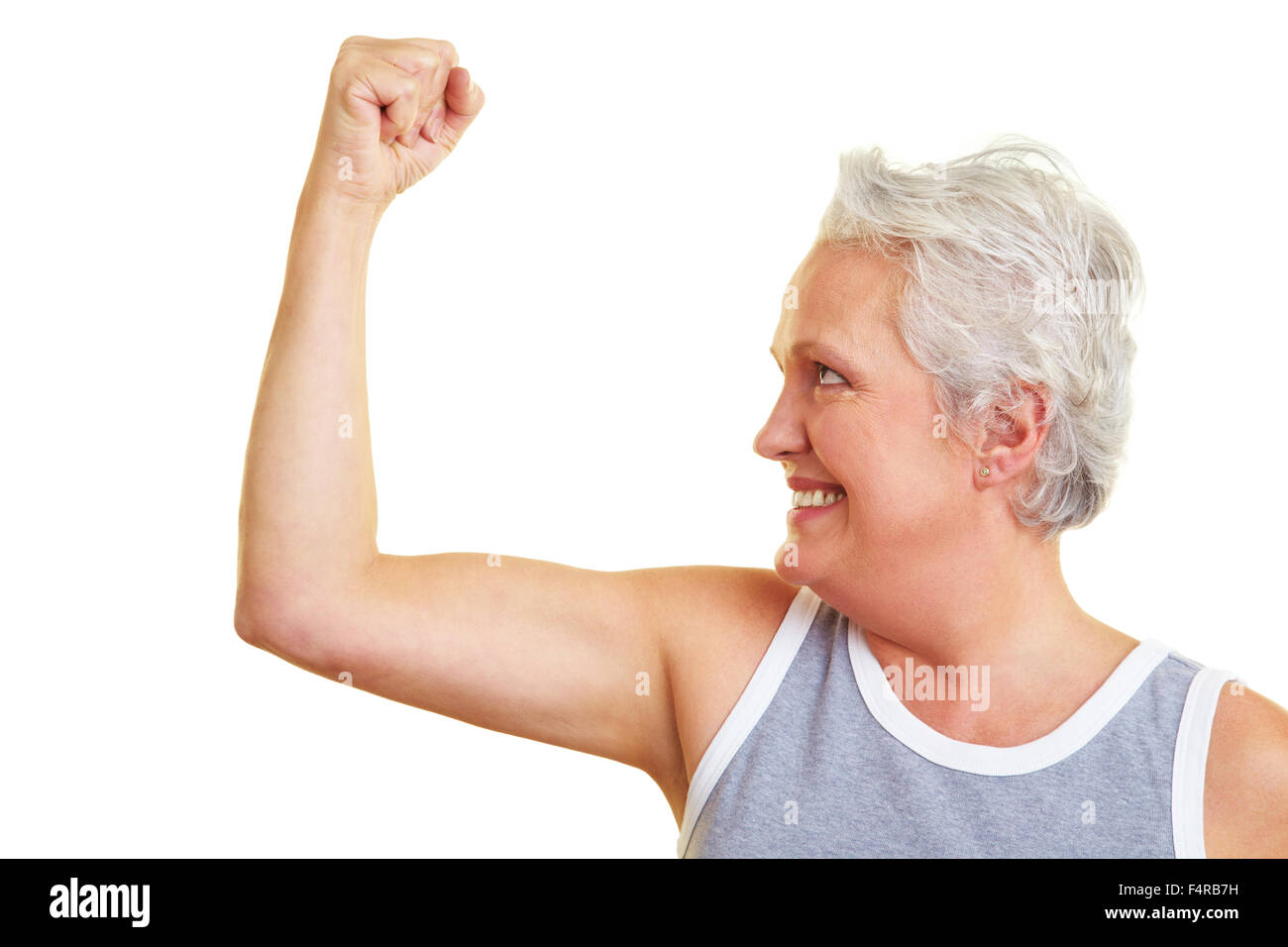 Happy senior woman showing her upper arm muscles Stock Photo