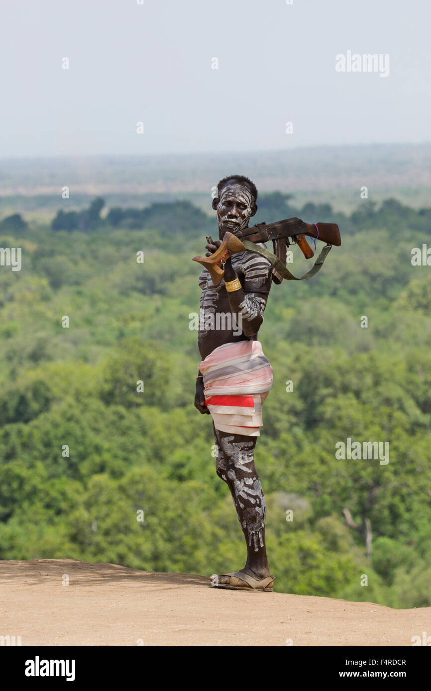 Young male Karo tribe boy with AK-47 rifle . Omo Valley, Ethiopia Stock Photo
