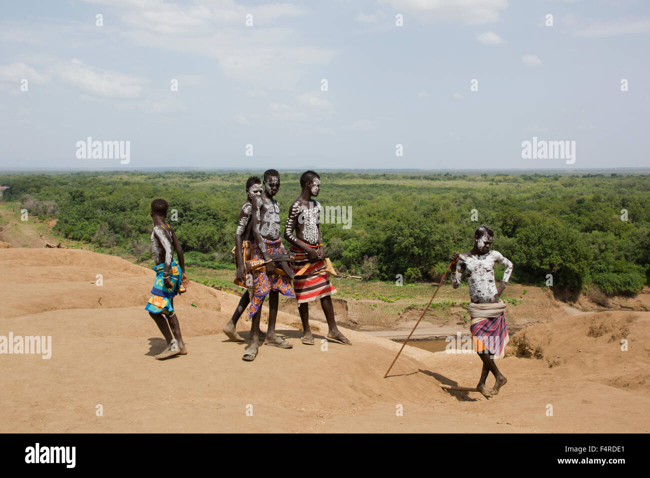 A group of young Karo tribe boys with AK-47 rifle . Omo Valley, Ethiopia Stock Photo