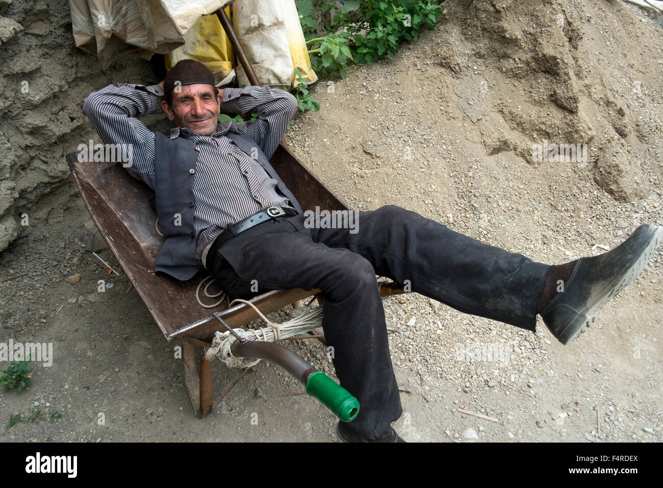 An Iranian man resting on a wheel barrow in Masouleh, Gilan, Iran Stock Photo