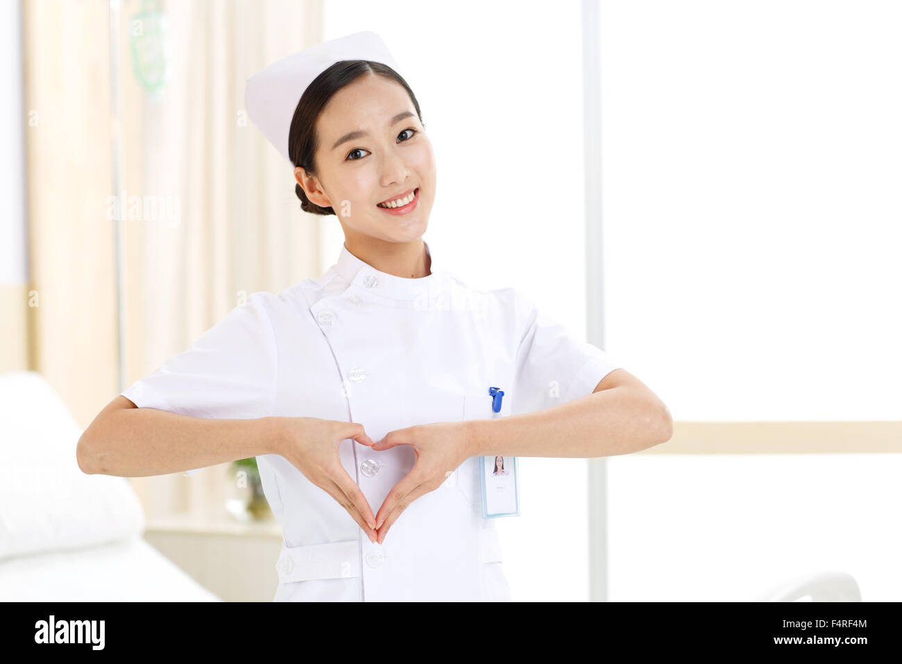 Young female nurses make a heart gesture Stock Photo