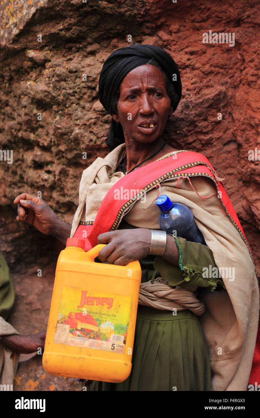 Pilgrim at the rock-hewn churches in Lalibela, containers for holy ...
