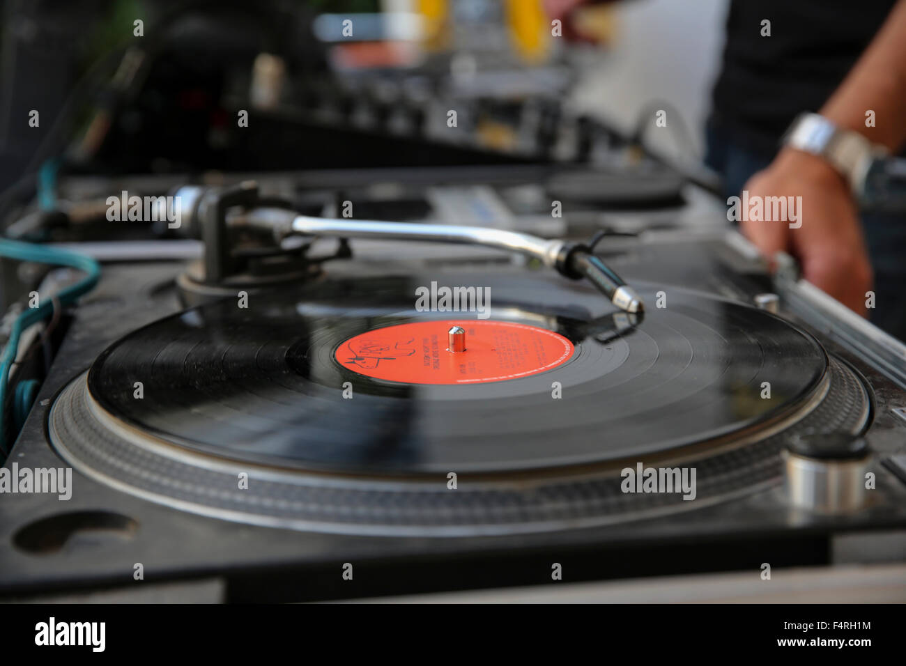 A disk jockey plays music on a record player at a party Stock Photo